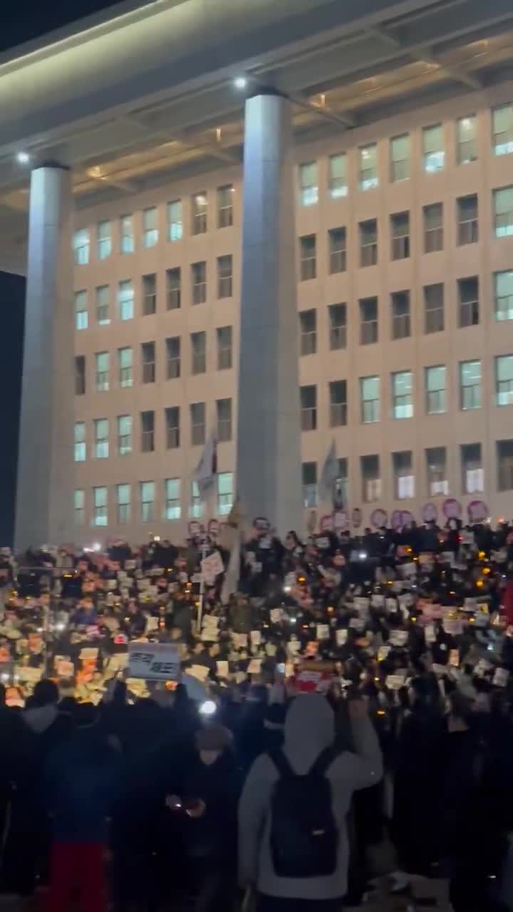 Dramatische Szene auf den Stufen der südkoreanischen Nationalversammlung: Menschen mit Trommeln, Kerzen und im Chor singend schwören, weiter zu protestieren, bis Präsident Yoon sein Amt verlässt