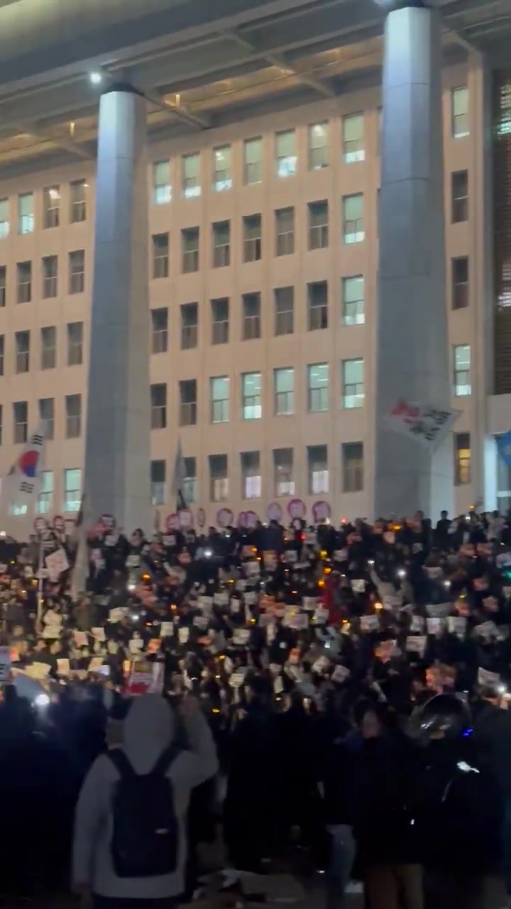 Dramatische Szene auf den Stufen der südkoreanischen Nationalversammlung: Menschen mit Trommeln, Kerzen und im Chor singend schwören, weiter zu protestieren, bis Präsident Yoon sein Amt verlässt