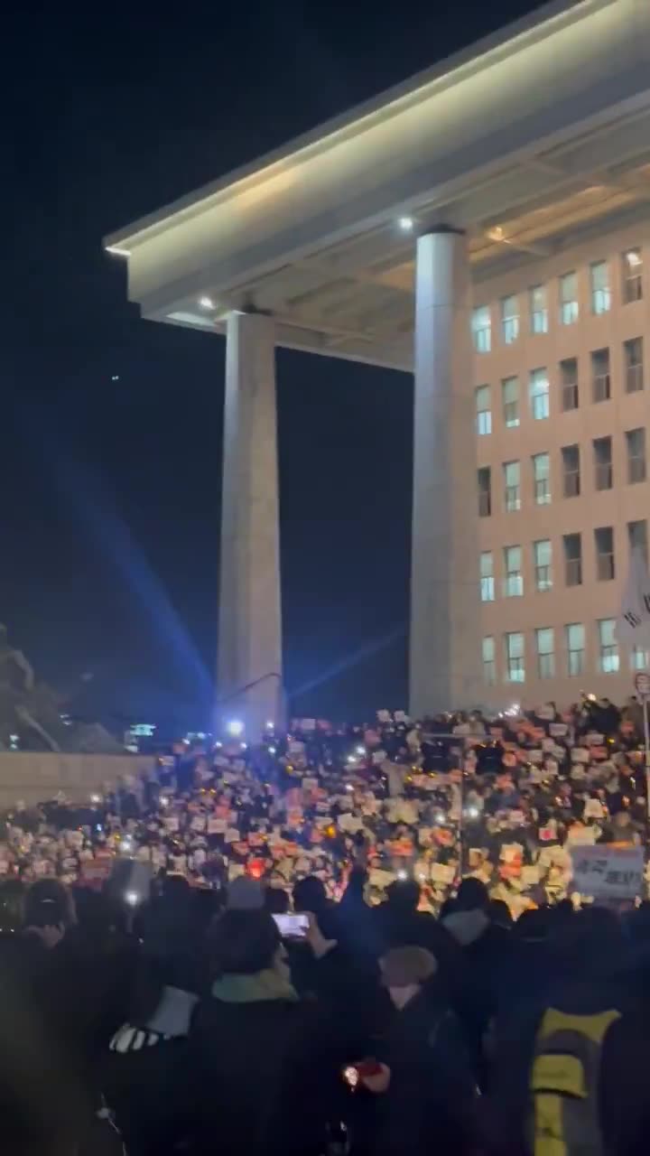 Dramatische Szene auf den Stufen der südkoreanischen Nationalversammlung: Menschen mit Trommeln, Kerzen und im Chor singend schwören, weiter zu protestieren, bis Präsident Yoon sein Amt verlässt