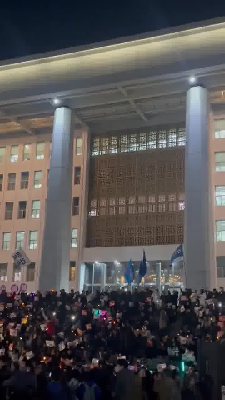 Dramatische Szene auf den Stufen der südkoreanischen Nationalversammlung: Menschen mit Trommeln, Kerzen und im Chor singend schwören, weiter zu protestieren, bis Präsident Yoon sein Amt verlässt